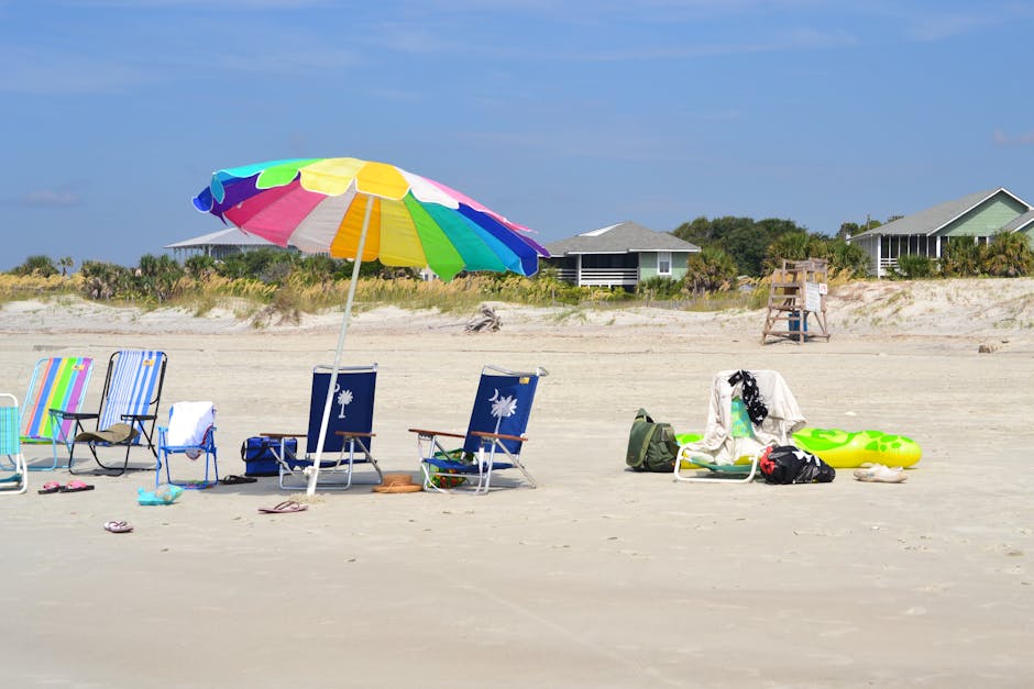 A family happily playing on the beach with colorful umbrellas and toys, showcasing cheap places to travel in U.S. with beaches