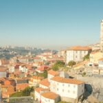 Scenic Portuguese coastline featuring colorful houses under clear blue skies, perfect for a comprehensive budget travel guide for 2026