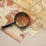 Traveler researching the best travel insurance options for 2026 on a laptop, with a map and travel guides nearby