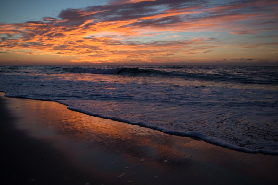 A happy family playing together on the beach during their affordable family vacation in the Outer Banks, North Carolina