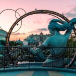Family smiling and posing in front of Orlando theme parks, showcasing top vacation spots for families on a budget