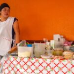 Vibrant street scene in Mexico City with colorful buildings and food vendors, showcasing a lively atmosphere