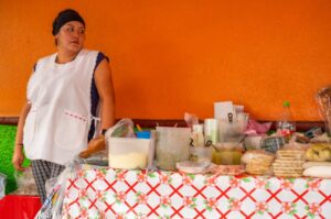 Vibrant street scene in Mexico City with colorful buildings and food vendors, showcasing a lively atmosphere