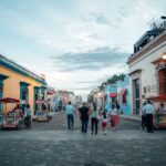 Colorful architecture in Oaxaca, Mexico, featuring vibrant buildings and street food vendors bustling in the scene