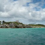 Tropical beach with turquoise waters and ancient ruins, showcasing one of the cheap countries to visit with beaches